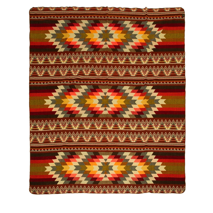 Ganze Ansicht einer gewebten Alpaka-Decke, 'Antisana Orange', mit lebhaften geometrischen Rauten- und Zickzackmustern auf dunklem, gestreiftem Hintergrund.