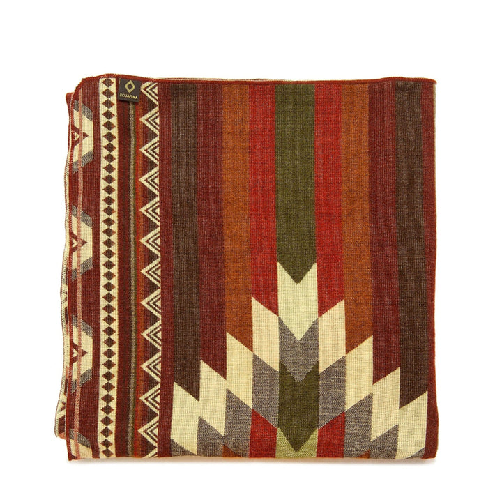 Gefaltete Alpaka-Decke mit einem 'ECUAPINA'-Etikett, die die satten vertikalen Streifen und das große geometrische Pfeilmuster hervorhebt