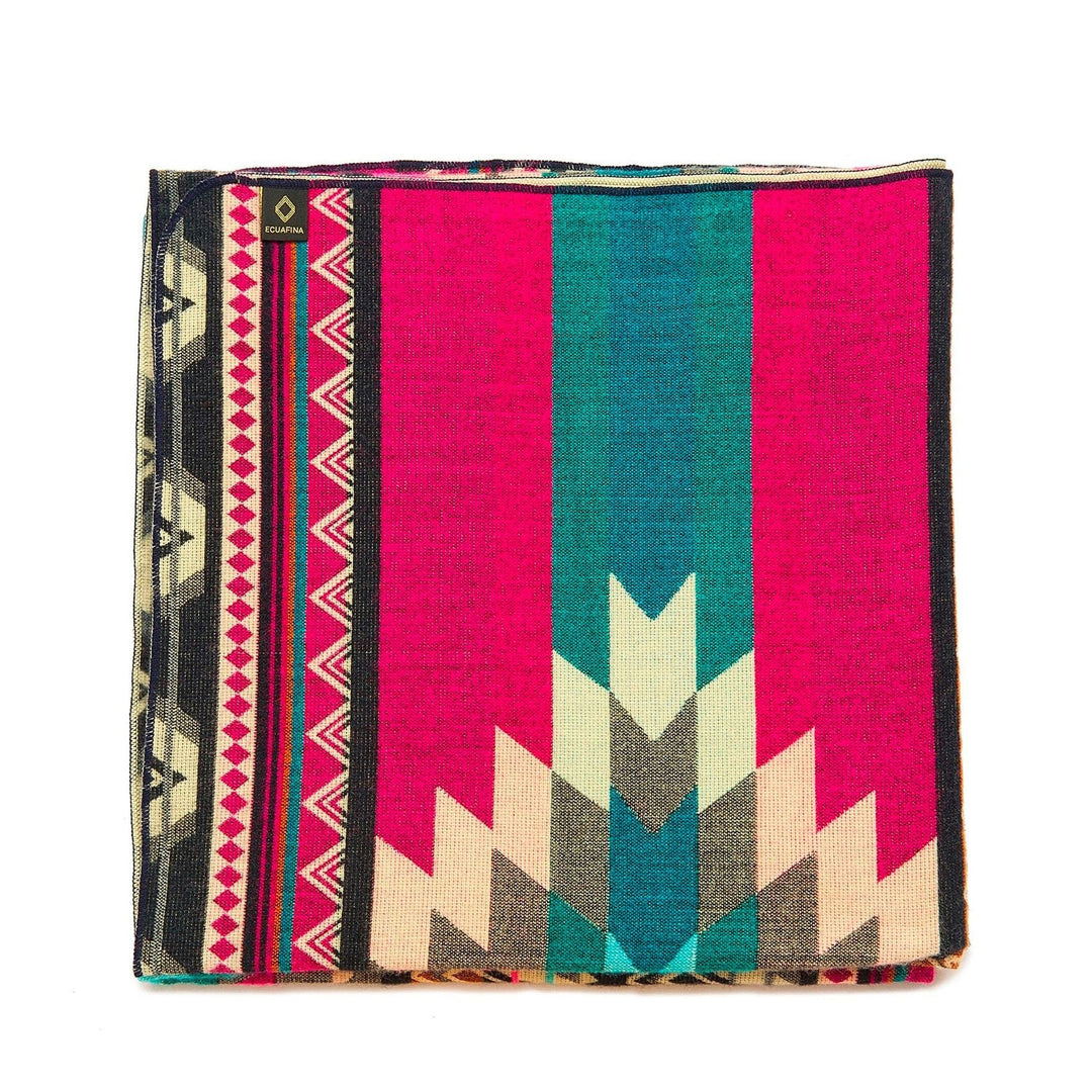 Gefaltete Alpaka-Decke 'Antisana Lila' mit dominanten leuchtend pinken Streifen und einem geometrischen Pfeilmuster.