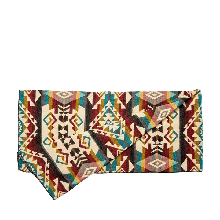 Gefaltete Alpaka-Decke 'Chimborazo Mehrfarbig', die ein komplexes, mehrfarbiges Rauten- und Dreiecksmuster zeigt.