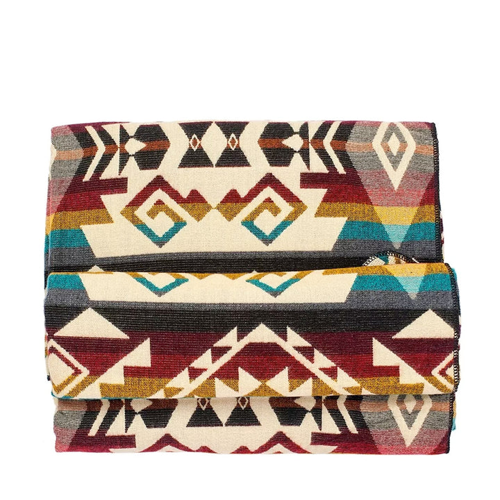 Stapel der gefalteten Alpaka-Decke 'Chimborazo Mehrfarbig', der die verschiedenen geometrischen Muster und Farben hervorhebt.