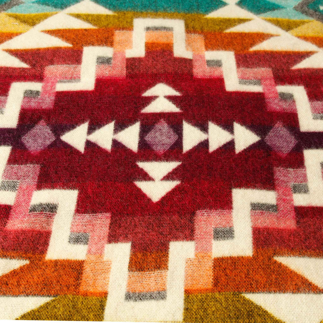 Detailaufnahme des zentralen, bordeauxroten Musters auf der dunklen Seite der Alpaka-Decke 'Chimborazo Rosa'.