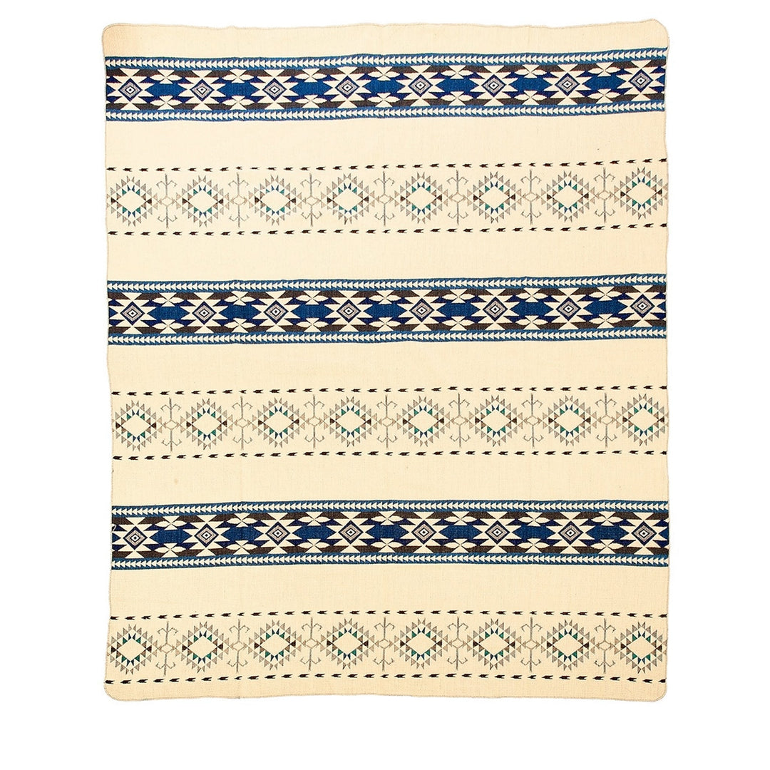 Ganze Ansicht der Rückseite der Alpaka-Decke 'Cotopaxi Blau' mit blauen geometrischen Mustern auf hellem, beigem Hintergrund.