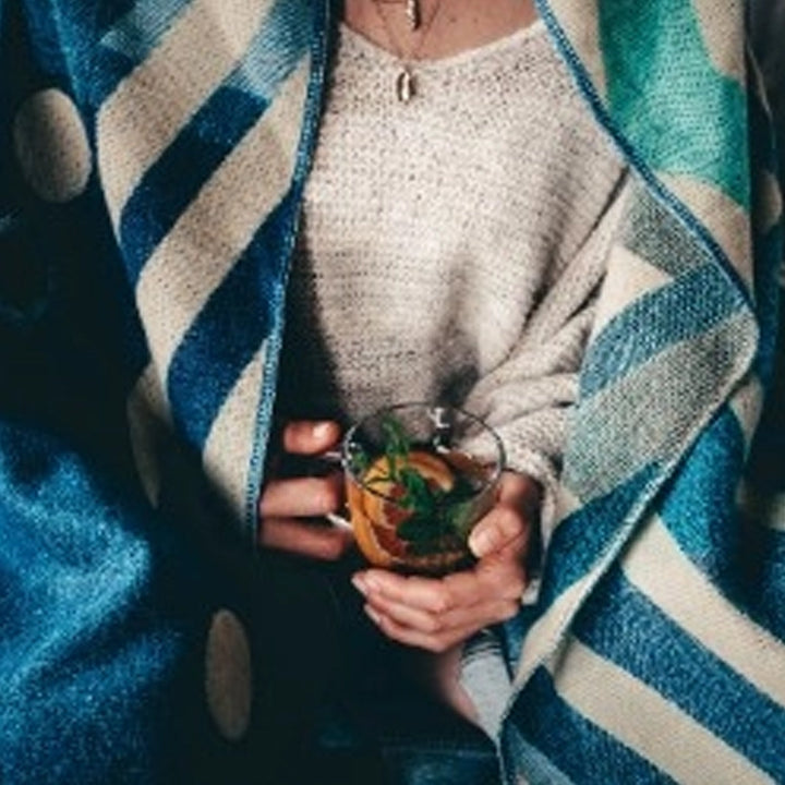 Ganze Ansicht der Rückseite der Alpaka-Decke 'Imbabura Blau', zeigt das dunkle, gewebte Rautenmuster in Blau und Beige.