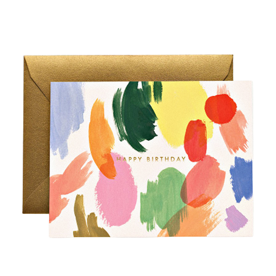 Geburtstagskarte mit goldenem „Happy Birthday“-Schriftzug und vielen bunten Pinselstrichen auf weißem Hintergrund.