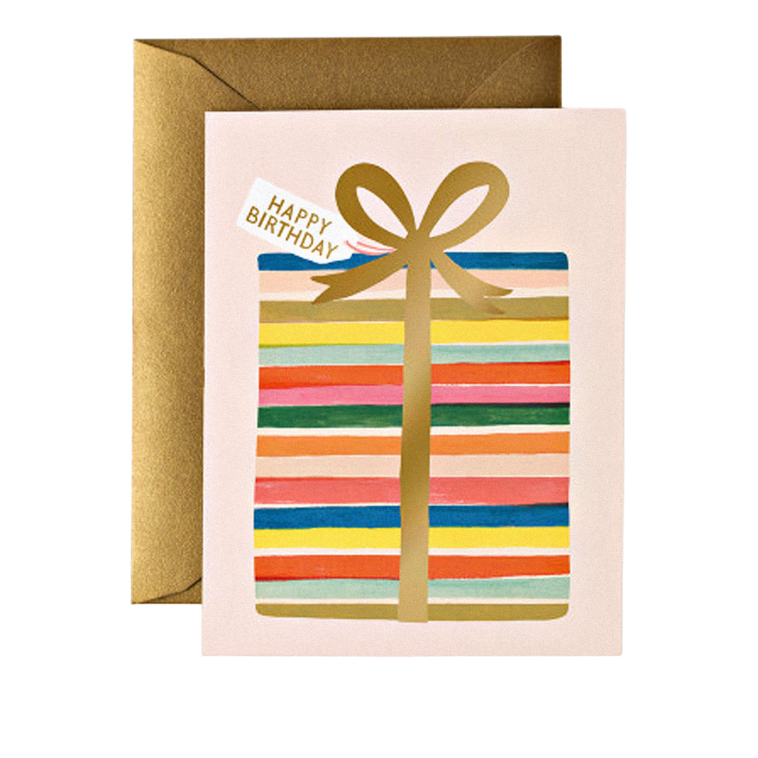 Geburtstagskarte mit goldenem Geschenkpaket, bunten Streifen und kleinem Schild mit „Happy Birthday“.