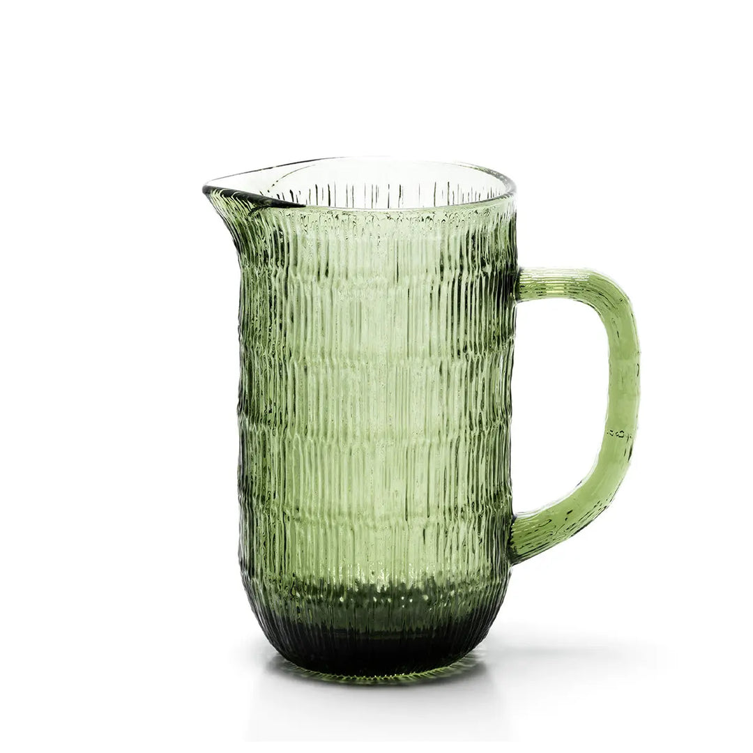 Grüne Karaffe mit Henkel und Ausgießer, geriffelte Oberfläche, freigestellt auf weißem Hintergrund