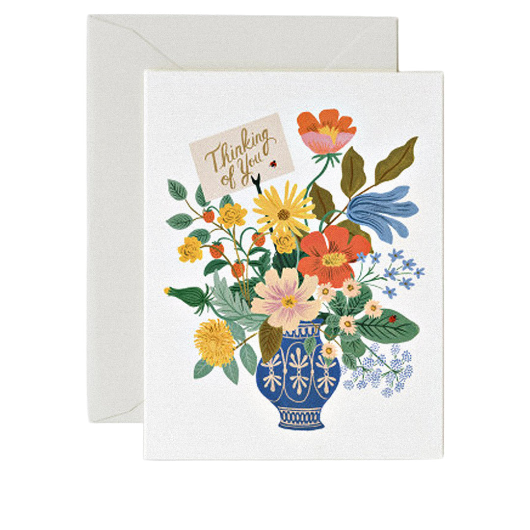 Grußkarte mit „Thinking of you“-Schriftzug und buntem Blumenstrauß in einer Vase.