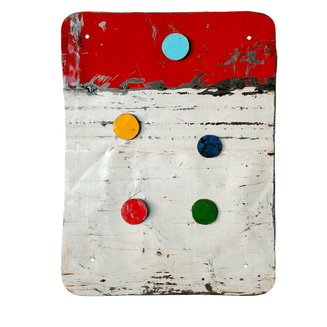 Rot-weiße Magnettafel aus upgecyceltem Ölfass mit fünf bunten Magneten und sichtbaren Gebrauchsspuren; ca. 38 
×
× 28 cm.
