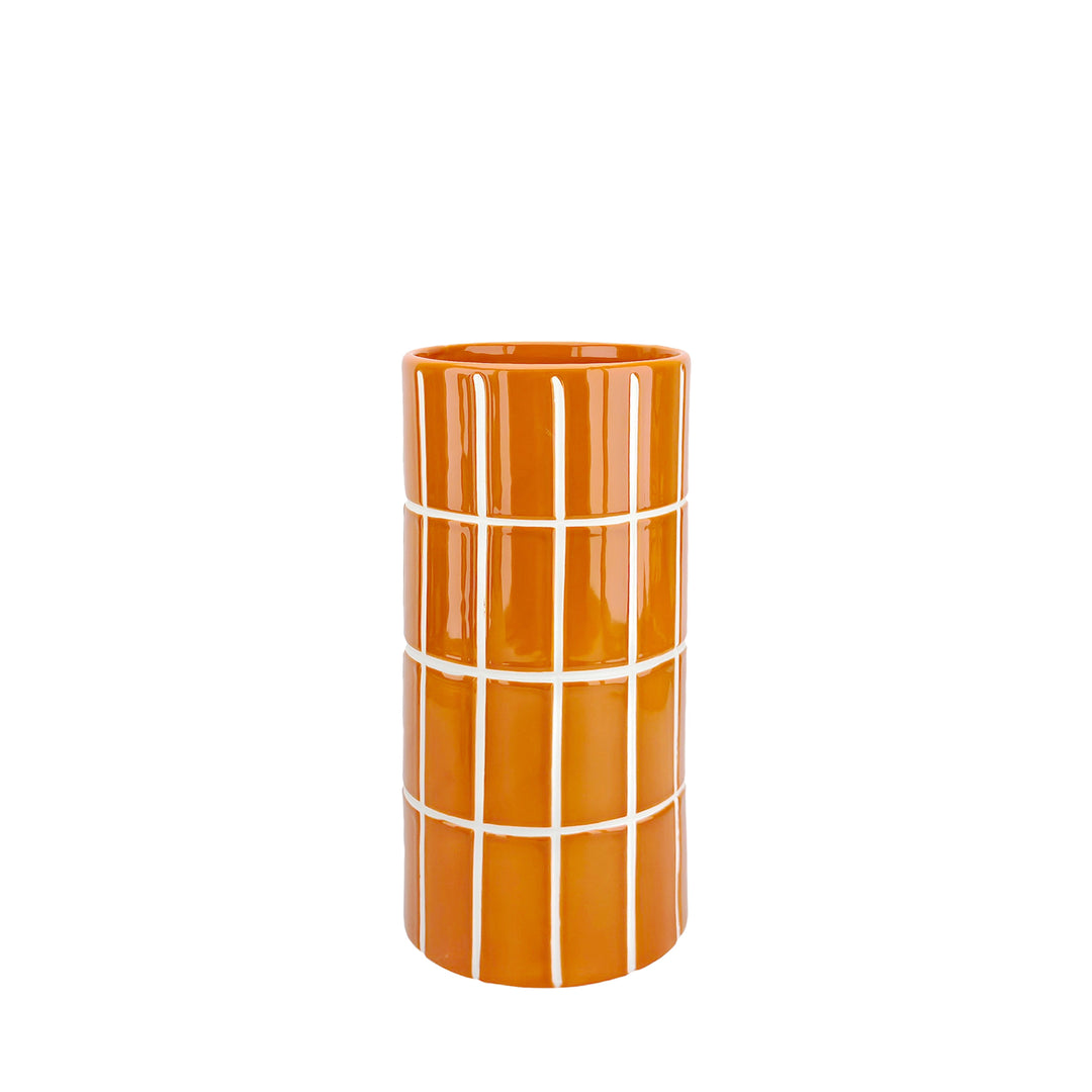 Orangefarbene Vase mit weißen waagerechten und senkrechten Linien vor hellem Hintergrund