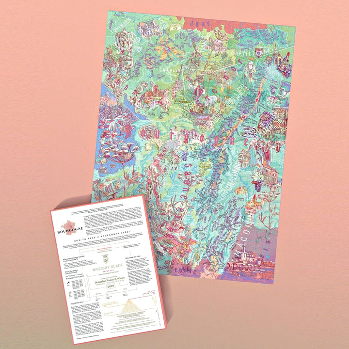 Das zusammengebaute Puzzle (Weinkarte von Burgund) liegt neben dem Begleitheft, das erklärt, wie man Burgunder Etiketten liest (mit Beispiel Musigny Blanc).