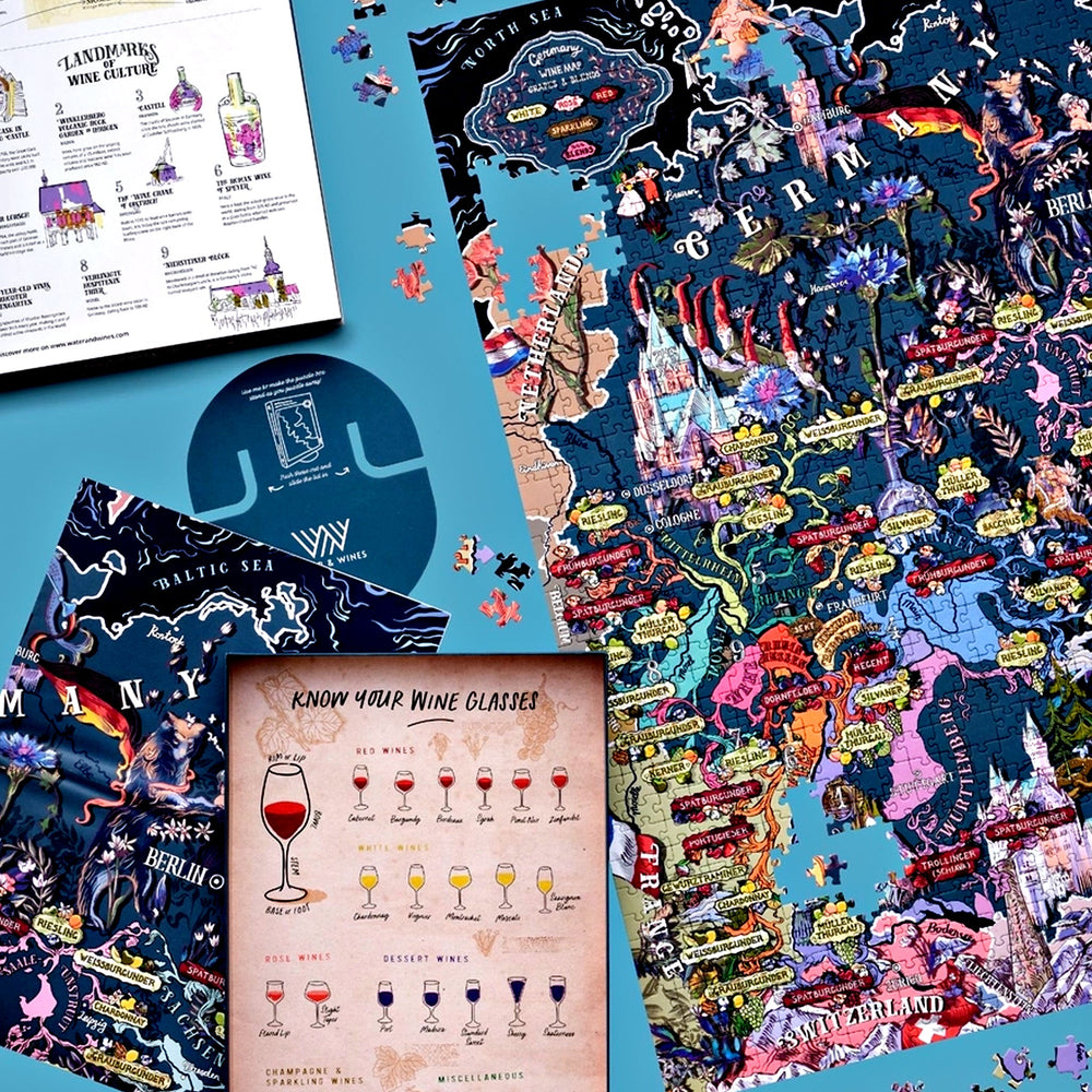 Arrangement aus dem unvollendeten Puzzle, der Box, einem runden Untersetzer und einem Begleitheft mit Erklärungen zu Weingläsern und Wein-Landmarks.