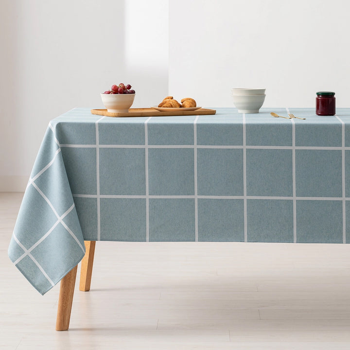 Türkise Tischdecke mit weißem Karomuster auf Holztisch mit Geschirr und Snacks