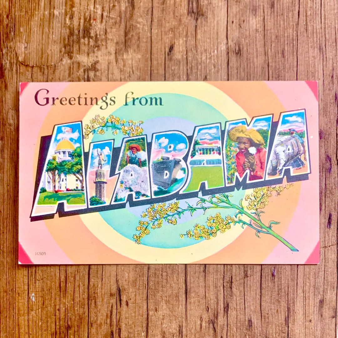 Vintage-Postkarte "Greetings from ALABAMA" mit bunten Collagen in den Buchstaben, umgeben von einem Regenbogen-Hintergrund und Blumen.