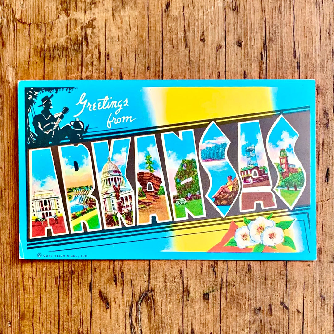 Vintage-Postkarte "Greetings from ARKANSAS" auf blau-gelbem Grund, der Schriftzug ist mit Sehenswürdigkeiten des Staates gefüllt und zeigt Baumwollblüten.