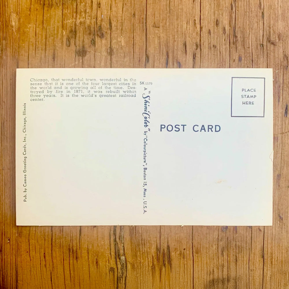 Rückseite von Vintage-Postkarte "Greetings from CHICAGO ILLINOIS" mit städtischen Motiven in den Buchstaben vor einem leuchtend gelb-rotem Hintergrund.