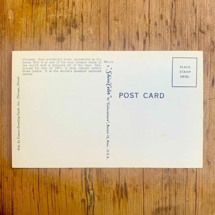 Rückseite von Vintage-Postkarte "Greetings from CHICAGO ILLINOIS" mit städtischen Motiven in den Buchstaben vor einem leuchtend gelb-rotem Hintergrund.