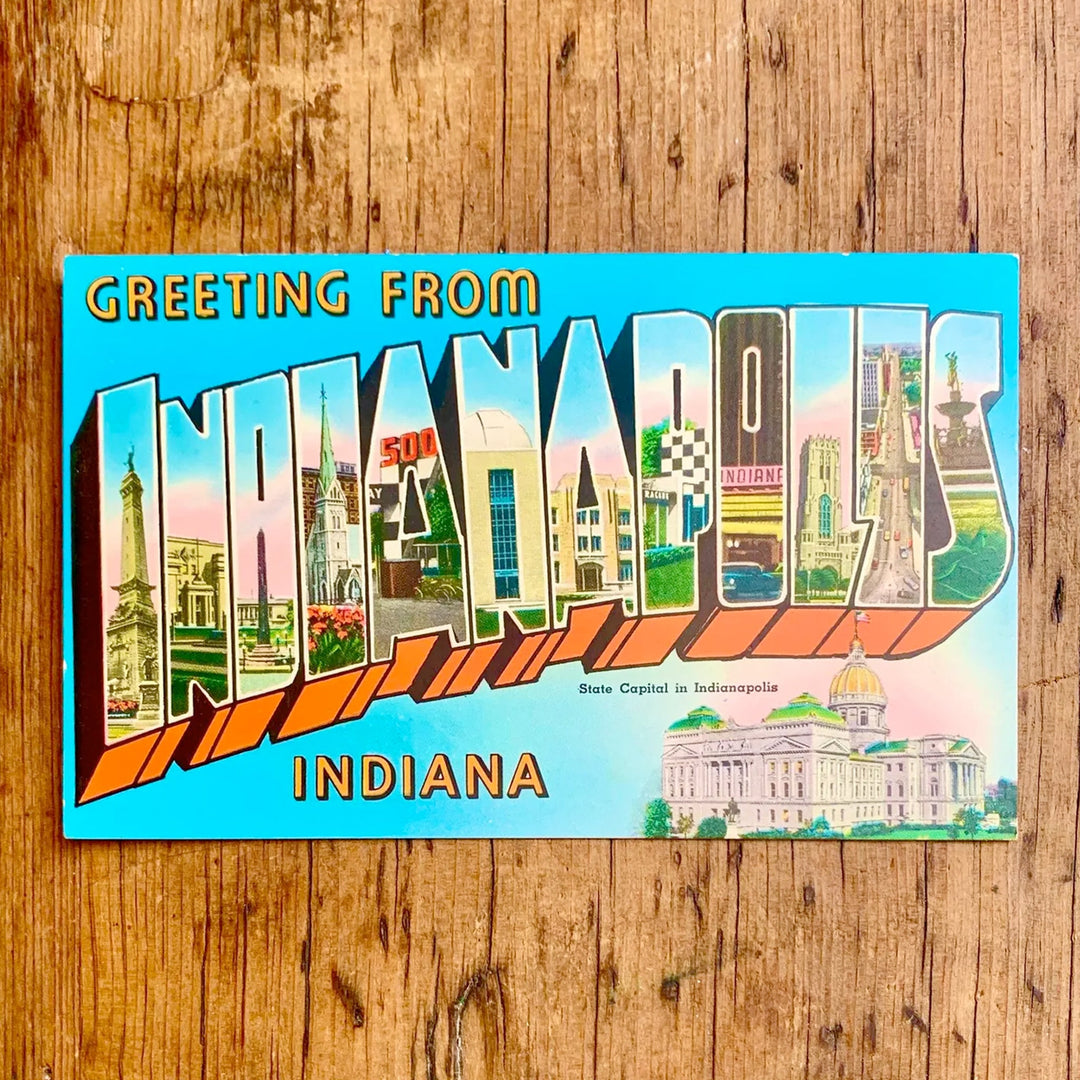 Vintage-Postkarte "GREETING FROM INDIANAPOLIS INDIANA" auf blauem Hintergrund, der Schriftzug ist mit Sehenswürdigkeiten der Stadt gefüllt, darunter das State Capitol.