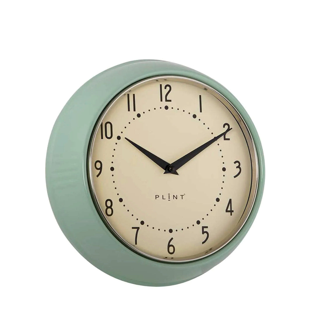 Blattgrüne Retro-Wanduhr mit cremefarbenem Zifferblatt.