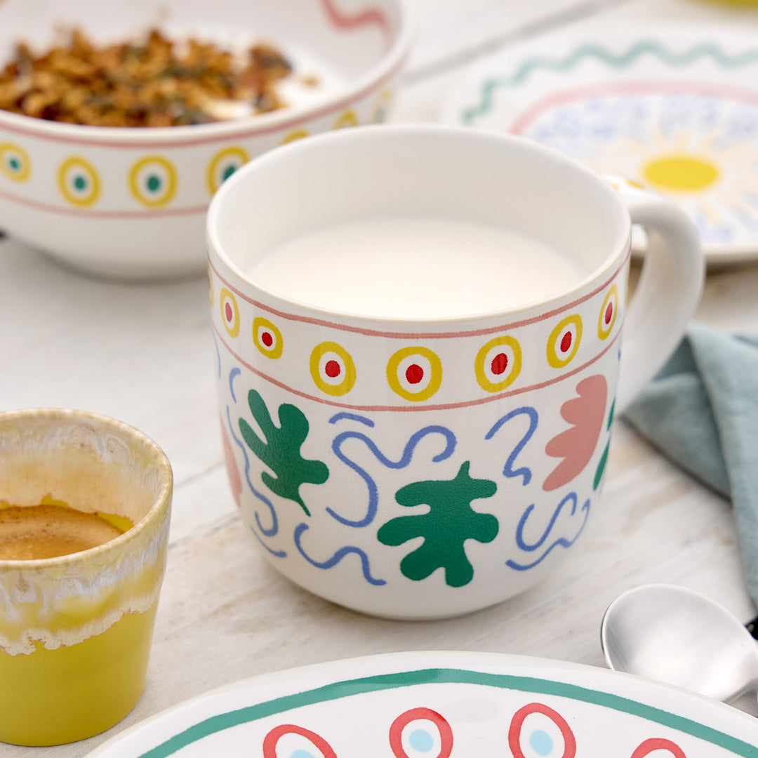 Weiße Tasse mit farbigen Formen und Punktbordüre
